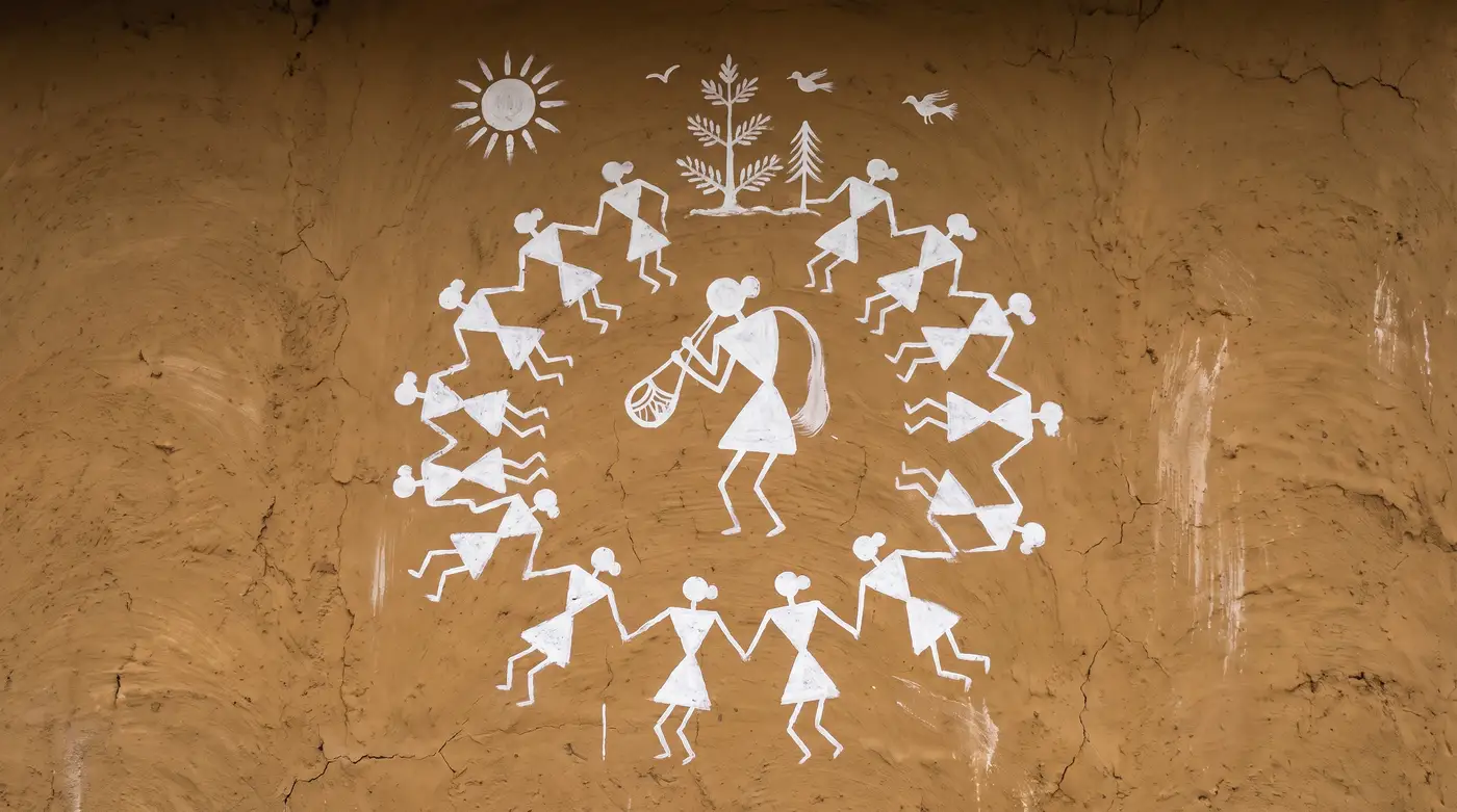 A Warli painting of dancing figures on an ochre wall
