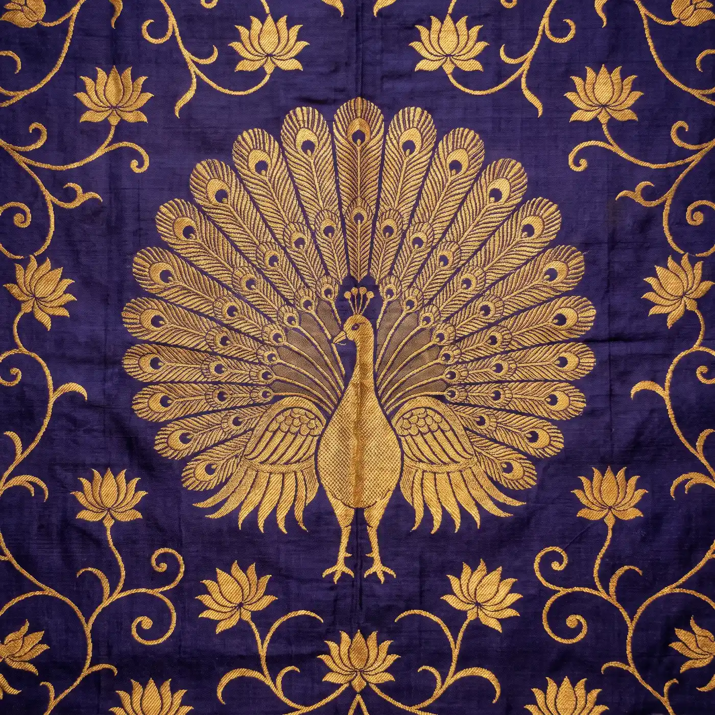A gold peacock motif woven on indigo Paithani silk